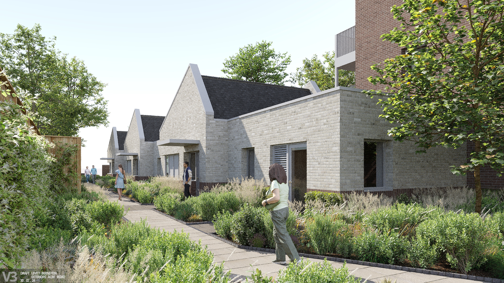 Image shows a woman walking along a paved pathway through flowers and grasses, in front of a row of grey brick bungalows.